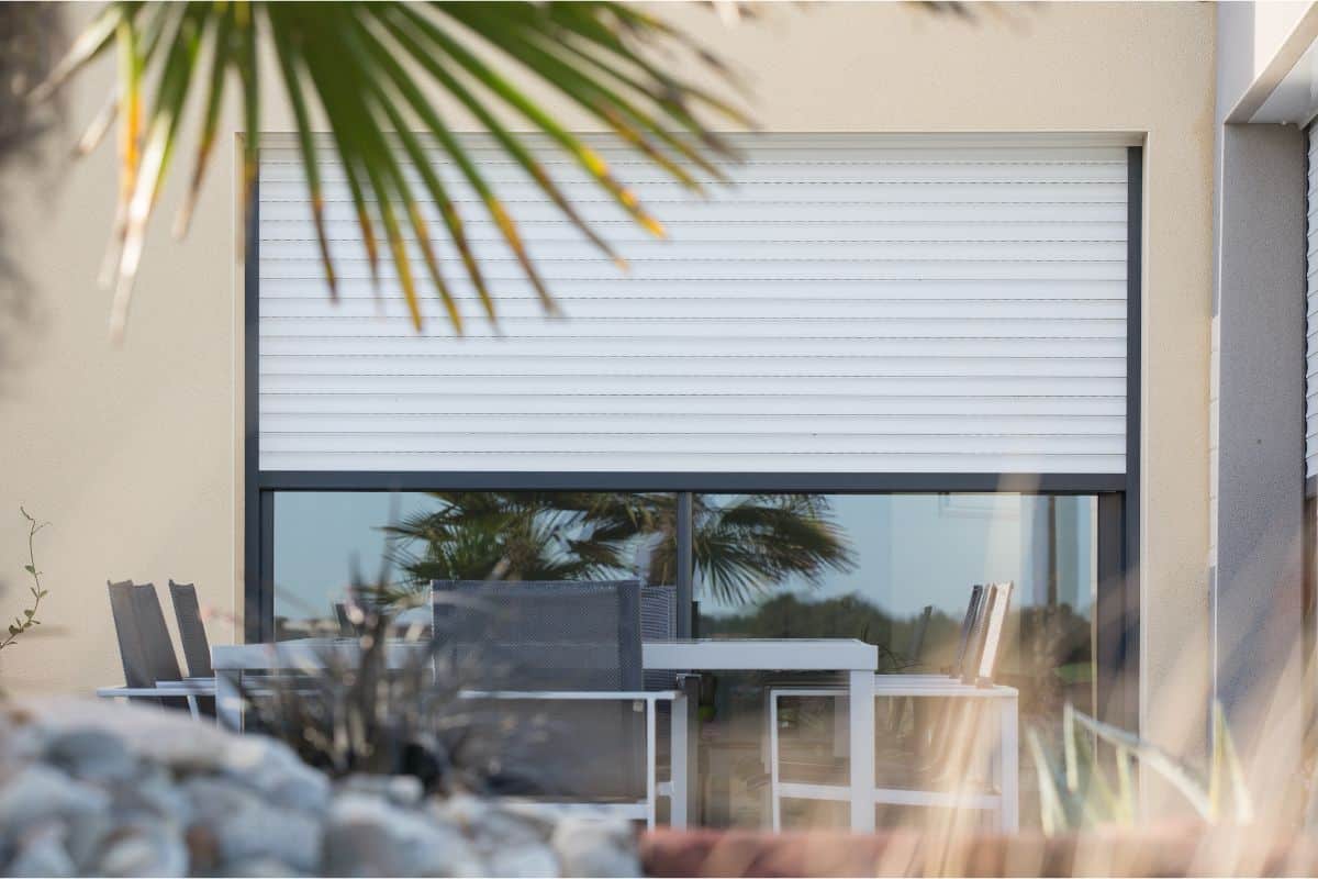 Persiennes blanches et mobilier extérieur